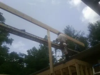 Carpenter setting a ridge beam over a new addition frame — Ice Dam Removal by Roofing Brothers in Meriden