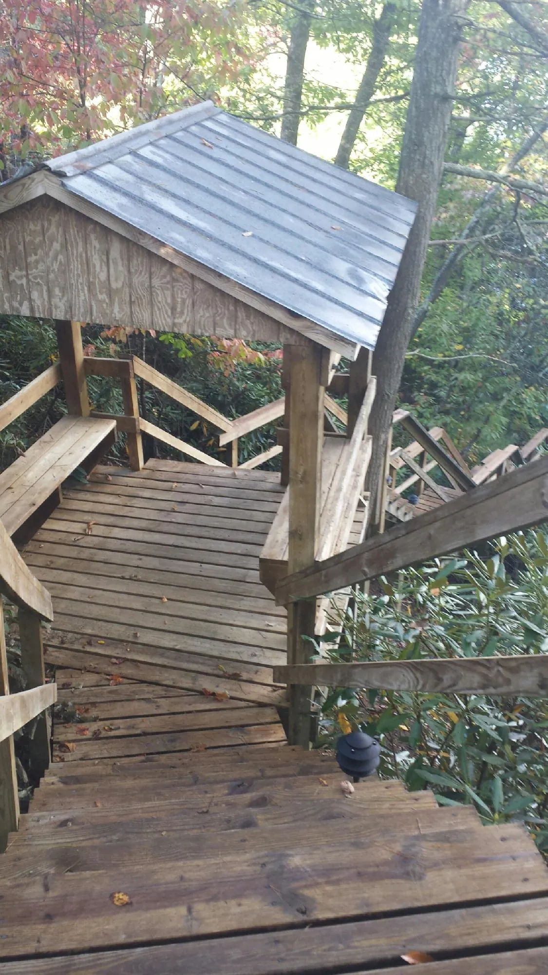 Metal roofed shelter over wooden steps on a wooded walkway — Skylight Repair & Installation work by our crew in Meriden